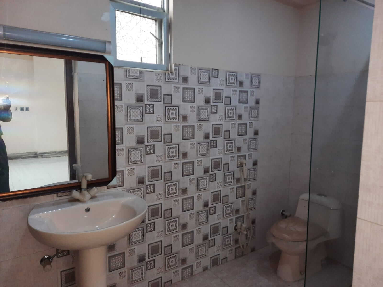 Dunes Marvel 3-Bedroom Apartment for Sale in Clifton Block 5 Karachi (12) Bathroom interior in Dunes Marvel 3-bedroom apartment Clifton Block 5 Karachi with sink mirror toilet and tiled walls