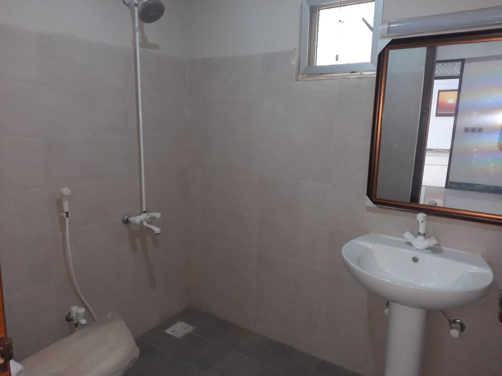 Dunes Marvel 3-Bedroom Apartment for Sale in Clifton Block 5 Karachi (14) Tiled bathroom with shower and pedestal sink in Dunes Marvel Clifton Block 5 Karachi