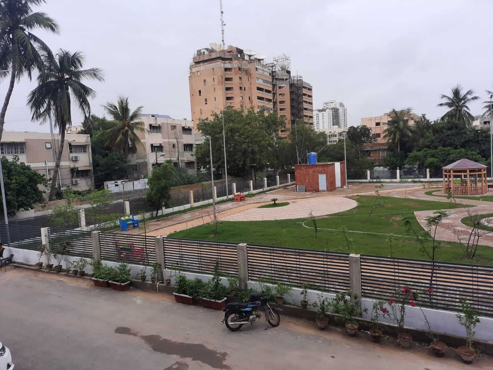 Dunes Marvel 3-Bedroom Apartment for Sale in Clifton Block 5 Karachi (6) Clifton Block 5 Karachi residential park with green lawns, pathways, palm trees and surrounding apartment buildings near Dune