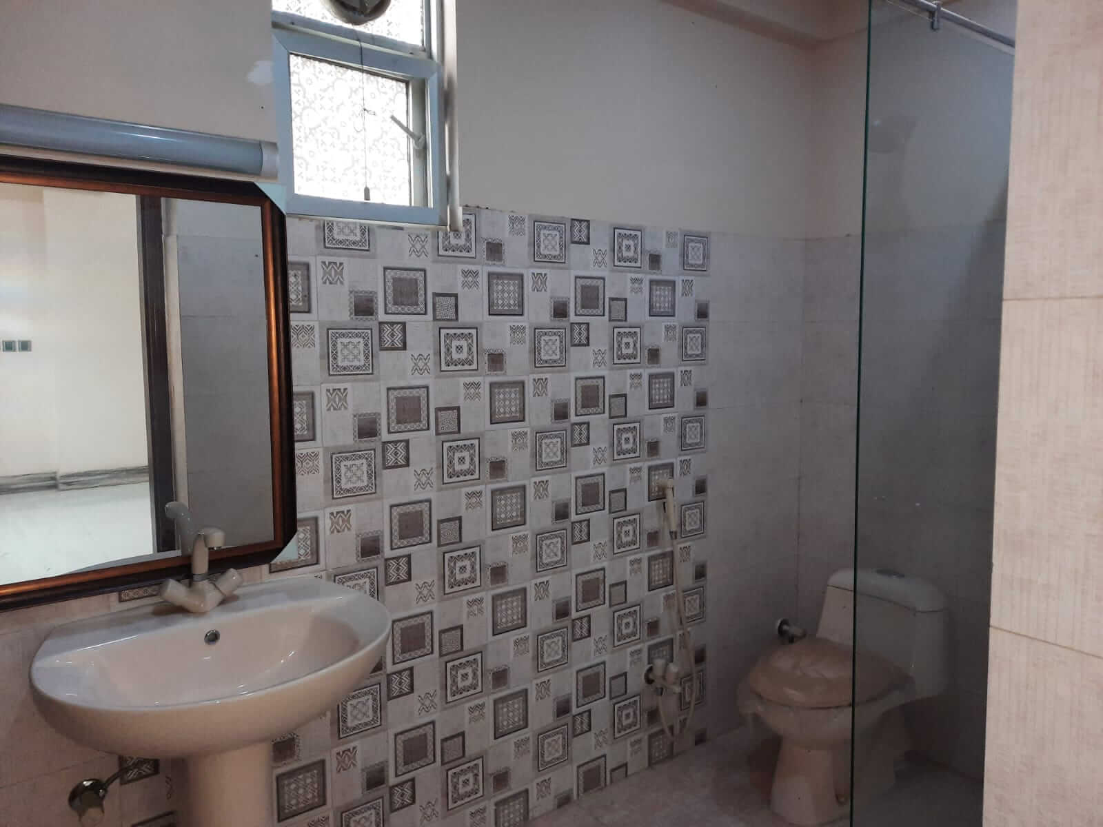 Dunes Marvel 3-Bedroom Apartment for Sale in Clifton Block 5 Karachi (9) Bathroom with pedestal sink, mirror and toilet in Dunes Marvel 3-bedroom apartment Clifton Block 5 Karachi