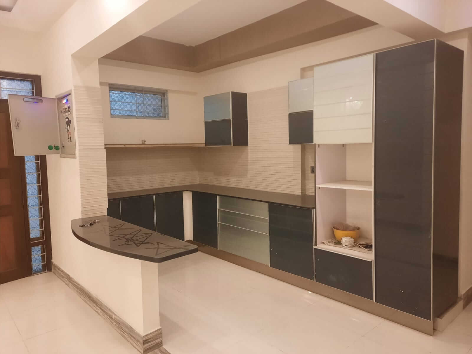 Dunes Marvel Clifton 3-Bedroom Flat for Sale in Clifton Block 5 Karachi (12) Modern kitchen with dark and white cabinets, breakfast bar in Dunes Marvel Clifton apartment, Clifton Block 5 Karachi