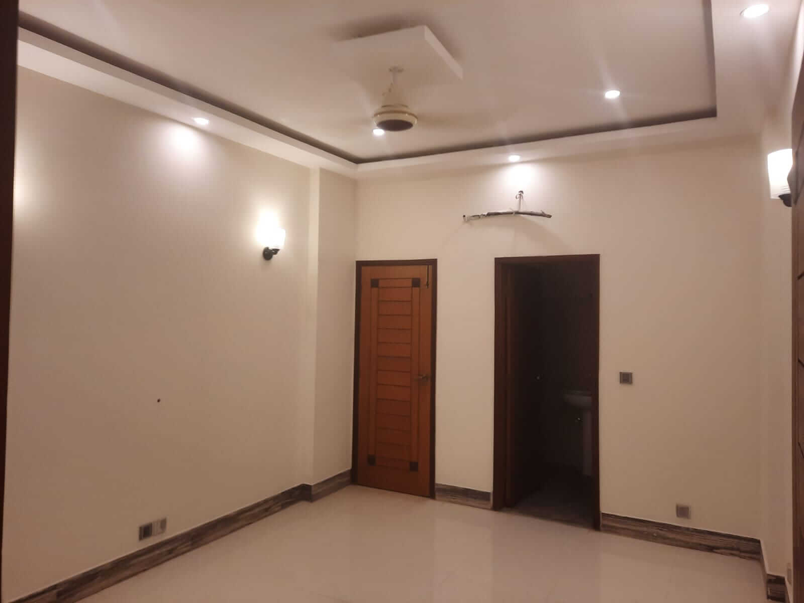 Dunes Marvel Clifton 3-Bedroom Flat for Sale in Clifton Block 5 Karachi (7) Empty room in Dunes Marvel Clifton flat Clifton Block 5 Karachi with wooden door tiled floor and bathroom access