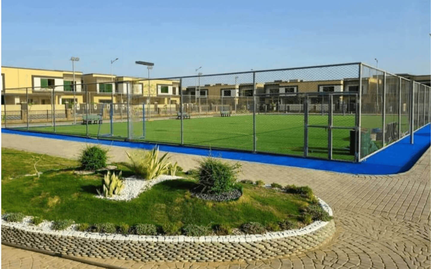 Askari Villas Karachi 270 Sq Yd Luxury by MaxX Capitals (8) Fenced padel court with blue-bordered artificial turf surrounded by modern Askari Villas at Askari VI, Karachi, landscaped ga