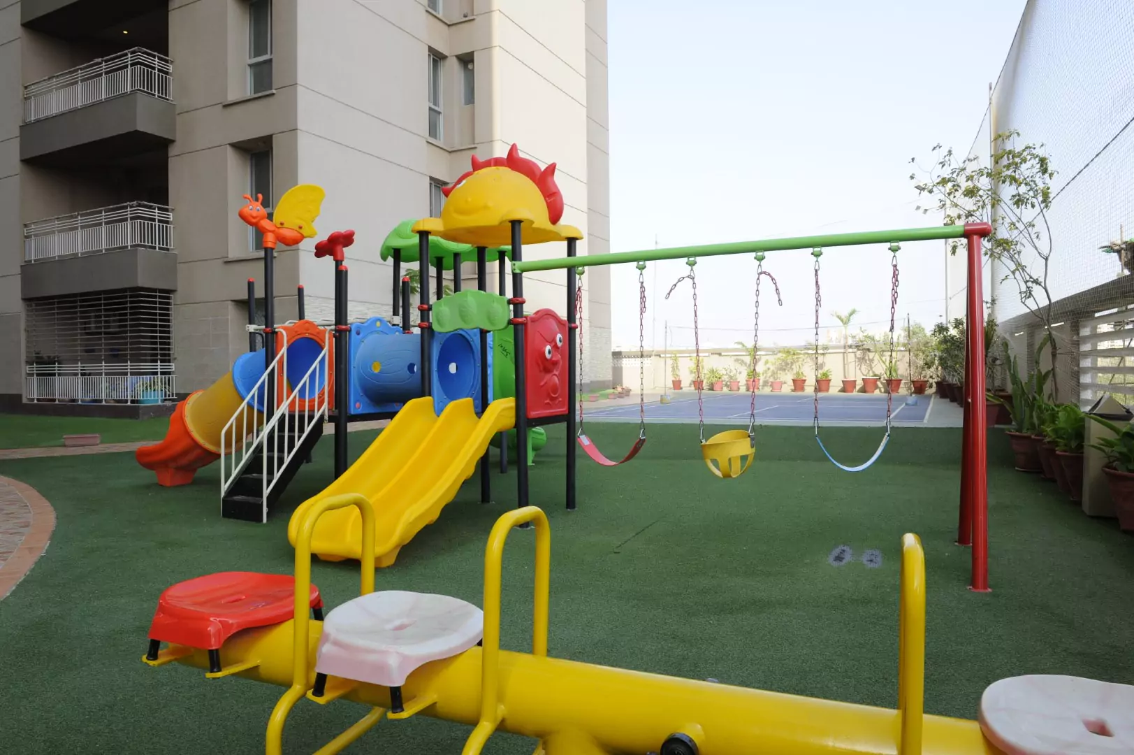 Luxury Flats & Penthouses For Sale in Lakhani Presidency (2) Colorful children's playground with slides, swings, climbers and monkey bars on artificial turf at Lakhani Presidency, Karach