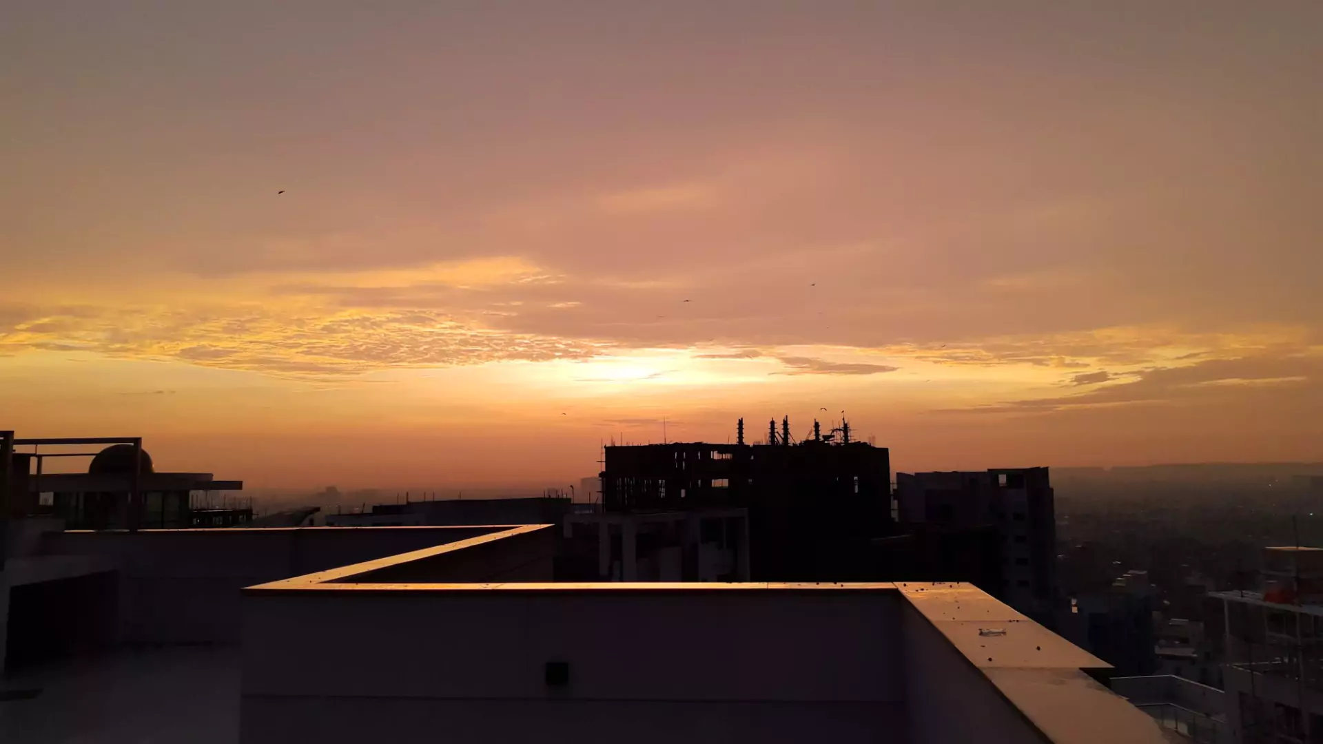 Luxury Flats & Penthouses For Sale in Lakhani Presidency (5) Sunset cityscape from Lakhani Presidency balcony in Karachi, modern high-rises and skyline visible