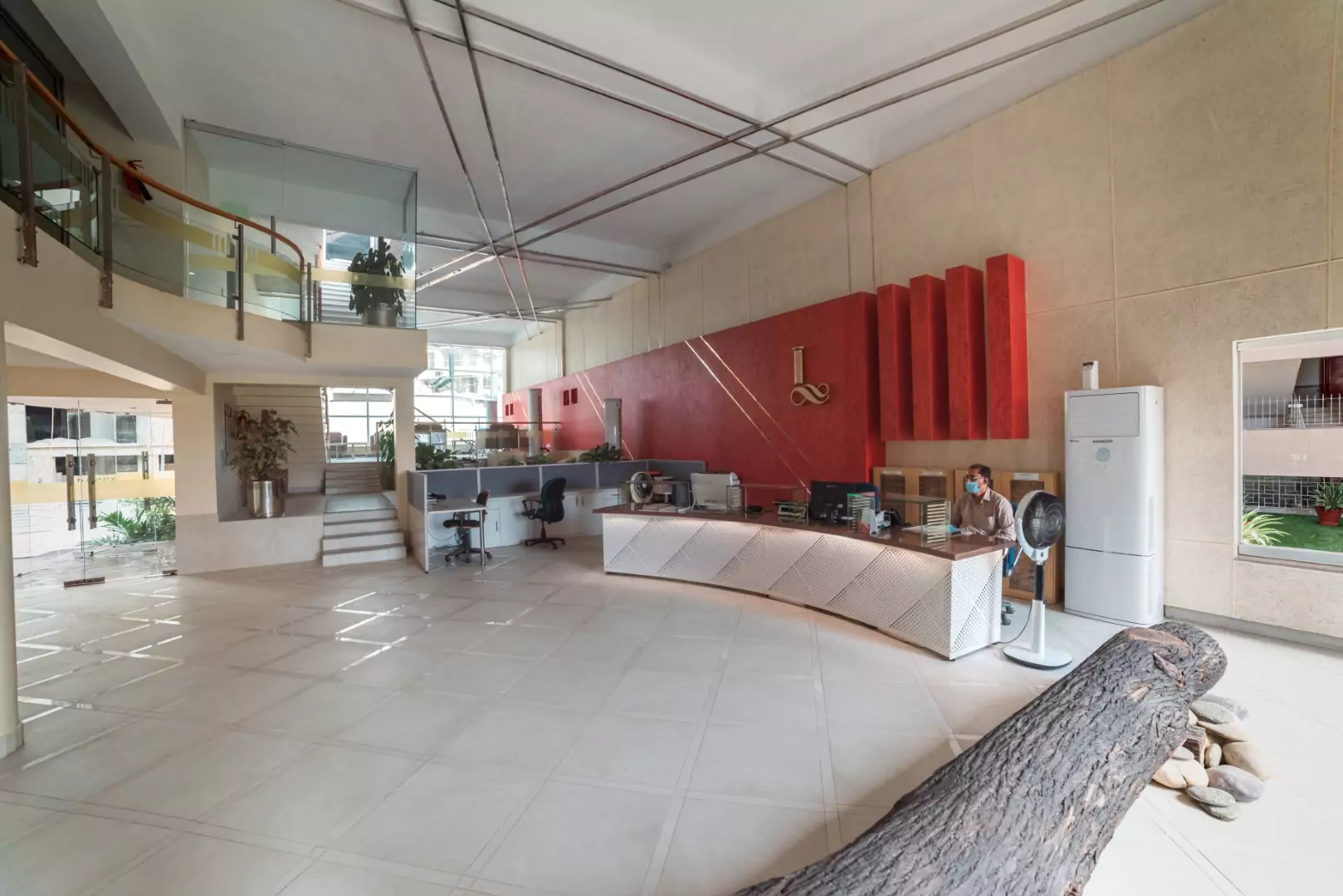 Luxury Flats & Penthouses For Sale in Lakhani Presidency (7) Spacious lobby at Lakhani Presidency in Karachi with curved reception desk, mezzanine balcony, plants, red pillars, and Lakha