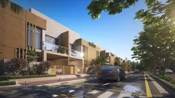 Row of modern beige townhouses with balconies, large windows, and greenery along tree-lined street in Titan Enclave, Karachi