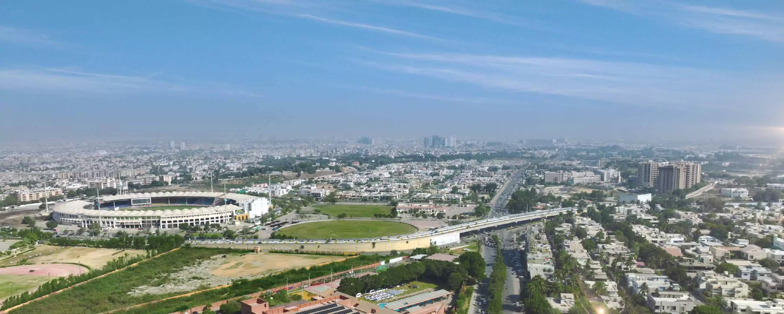 The Court Heights Karachi Near National Stadium Karachi Luxury Flats for Sale In Karachi Aerial panorama of Karachi near The Court Heights featuring National Stadium, green fields, flyover bridge, high-rises, and r
