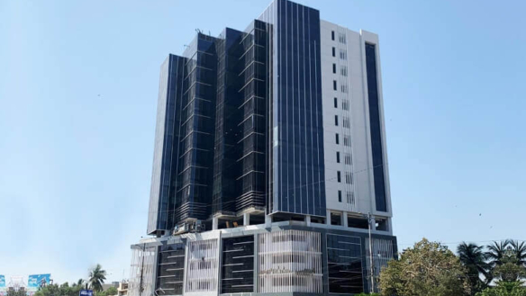 Emarah Suites Karachi Modern High-Rise Exterior With Black Glass Panels, White Frames, Scaffolding, And Palm Trees