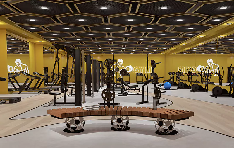 Titan One Luxury Flats Duplex Apartments & Penthouses For Sale In Callachi Co-Operative Housing Society Karachi (4) MaxX Capitals gym at Titan One Karachi with treadmills, weight machines, mirrors, and hexagonal ceiling lighting