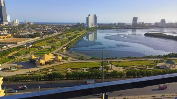 Clifton Marina High-Rise In Karachi Clifton With Modern Grey Facade, Balconies, Signage, Street-Level Entrance And Vehicles