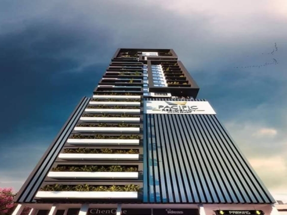 Towering Modern Facade Of Pacific Residency Clifton High-Rise With Glass Panels, Vegetated Balconies, And Prominent Signage
