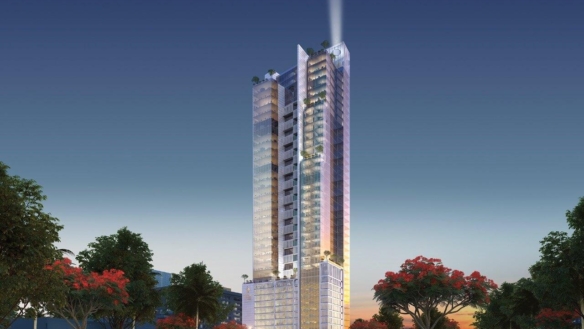 Modern High-Rise Tower With Illuminated Spire At Dusk, Glass Facades, Surrounded By Palm Trees And Red-Flowering Trees