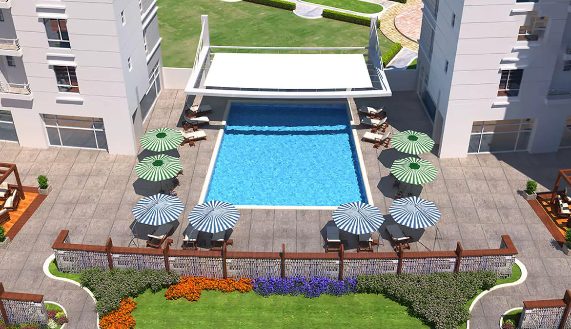 Luxurious 4-Bedroom Apartment For Sale in Com3 Tower Block 6 Clifton Karachi (1) Aerial view of Com3 Tower in Clifton with modern twin high-rise towers, curved commercial podium, palm trees, landscaped area