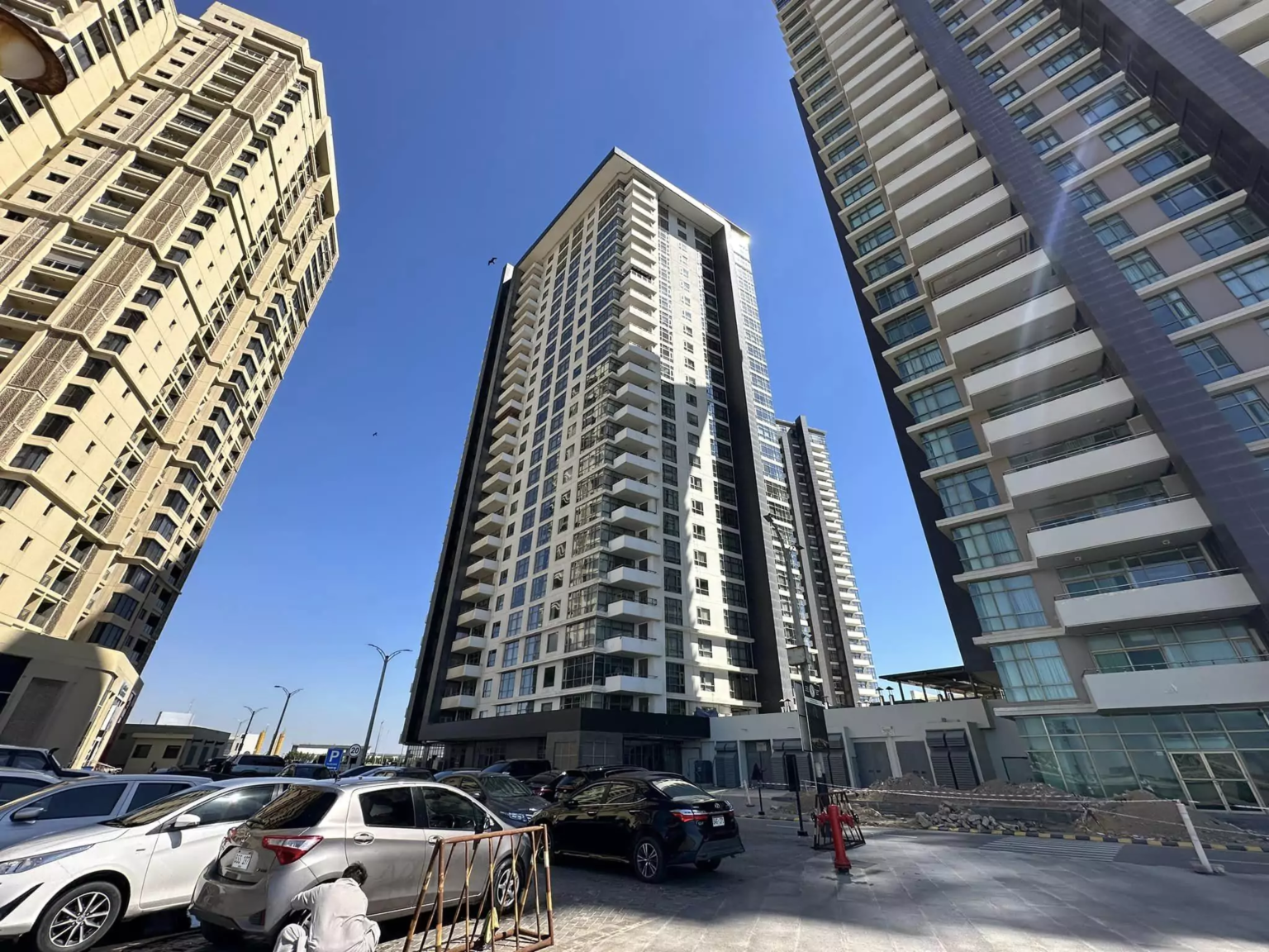 Luxury 3-Bedroom Sea View Apartment for Rent in Emaar Pearl DHA Phase 8 Karachi (11) Modern high-rise apartment towers in Emaar Pearl with sea view balconies, glass facades, and ground parking area