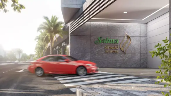 Saima Shield Towers exterior in Gulshan-e-Iqbal: modern stone facade, green logo signage, palm trees, zebra crossing, red sed