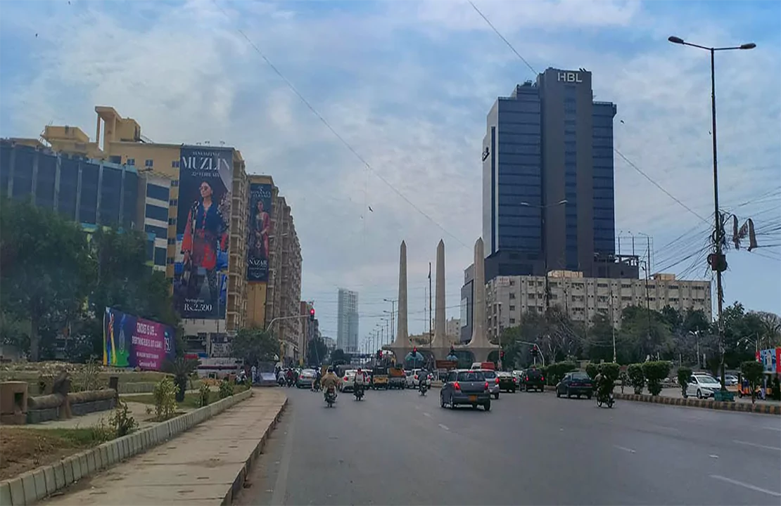 Luxurious 3-Bedroom Flat For Rent in Bath Island Karachi (1) Street view in Bath Island Karachi with high-rise buildings, billboards, traffic, palms, and obelisks near 3-bedroom flat for