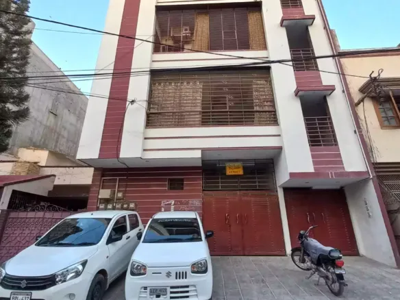 Ground Floor Portion For Sale In North Nazimabad Block C, Modern White House With Maroon Accents, Gated Driveway, Two Parked 