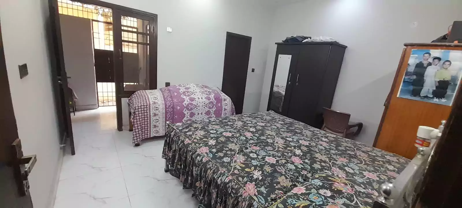 Prime Ground Floor Portion for Sale in North Nazimabad Block C Karachi (10) Bedroom in ground floor portion for sale North Nazimabad Block C with double bed floral bedding single bed wardrobe mirror ti