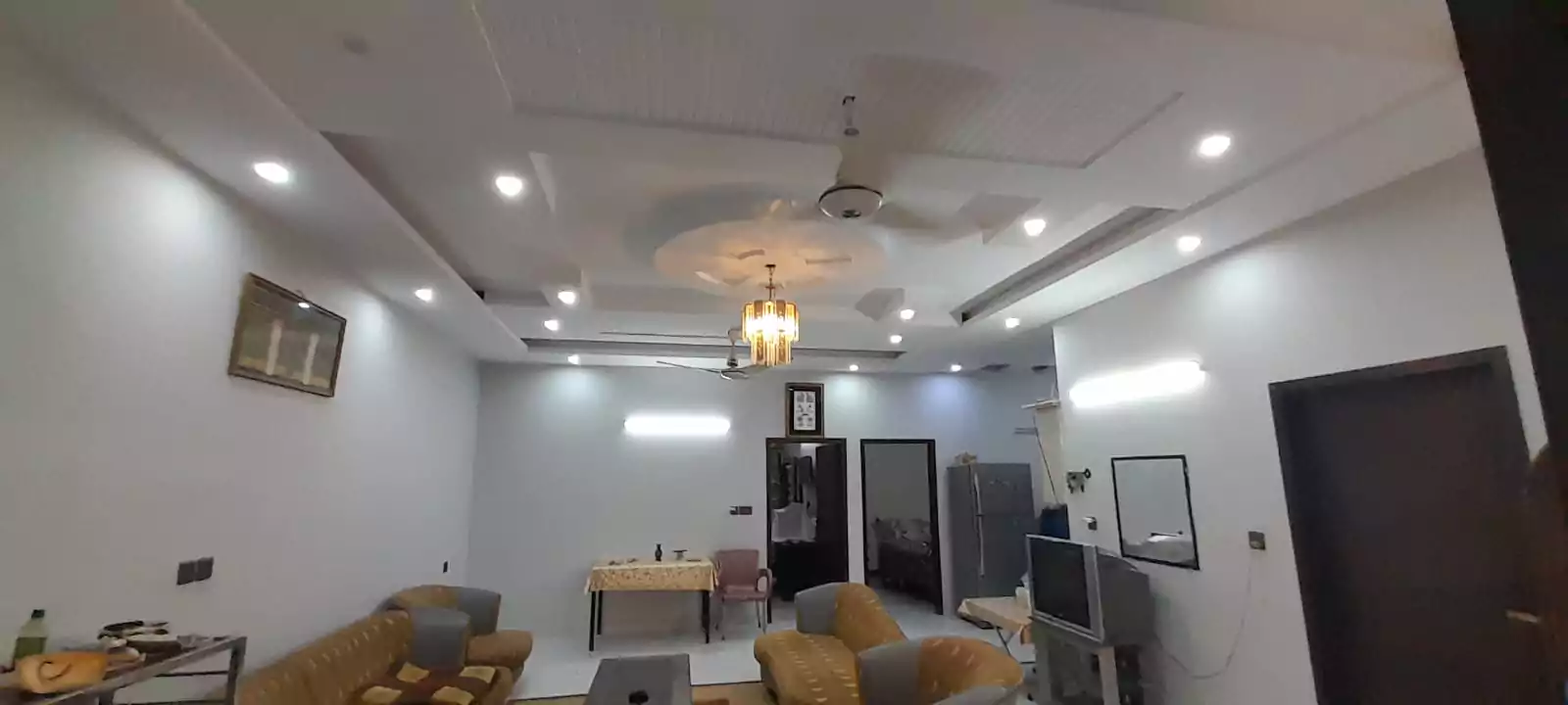 Prime Ground Floor Portion for Sale in North Nazimabad Block C Karachi (11) Spacious living room in ground floor portion for sale North Nazimabad Block C featuring beige sofas, TV unit, false ceiling w