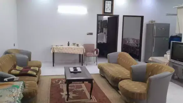 Spacious living room in North Nazimabad Block C ground floor portion with beige sofas, dining table, TV, fridge, wardrobe