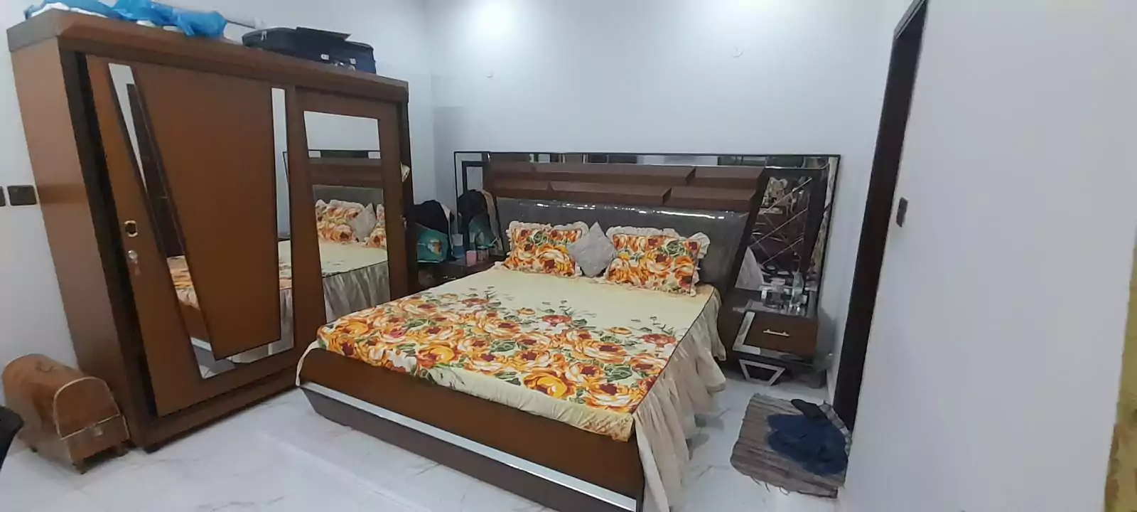 Prime Ground Floor Portion for Sale in North Nazimabad Block C Karachi (9) Bedroom in ground floor portion for sale North Nazimabad Block C with brown wooden mirrored wardrobe, double bed floral orang