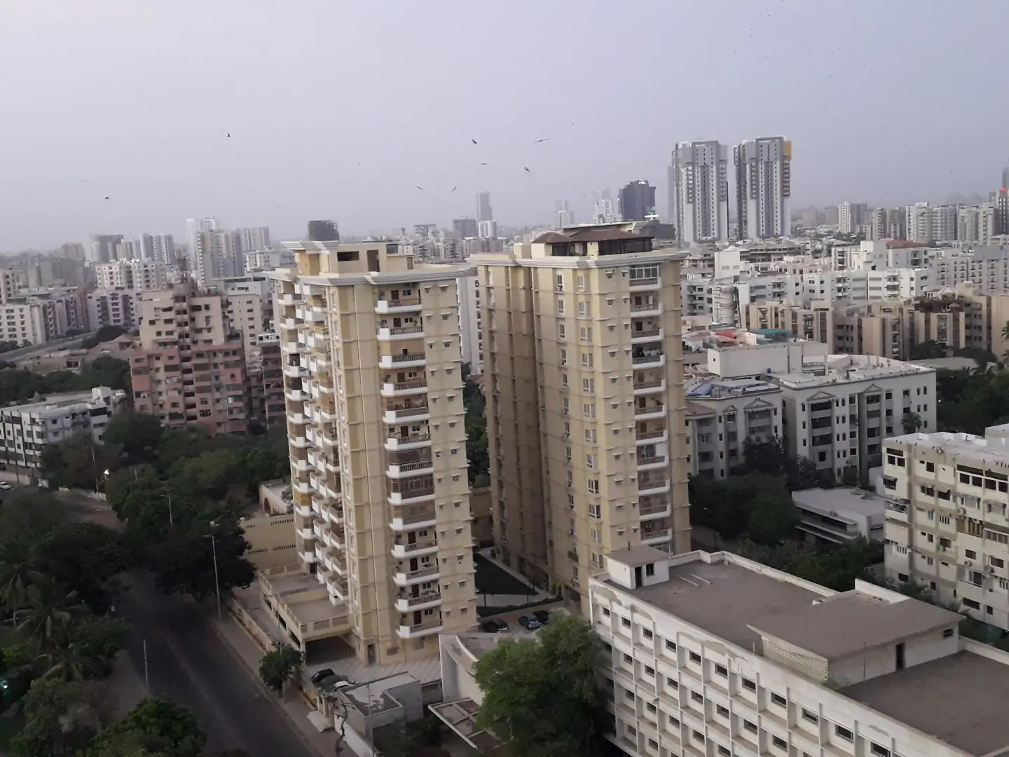 Luxurious 3-Bedroom Apartment For Sale In Zamzam Towers, Civil Lines Karachi (2) Twin beige high-rise towers of Zamzam Towers in Civil Lines with balconies, surrounded by urban apartments and trees