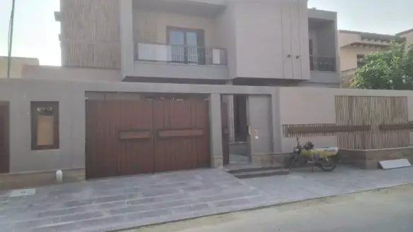 Luxurious Brand New House For Sale In Dha Phase 6 Karachi, Modern Beige Facade With Double Wooden Garage Doors And Balcony