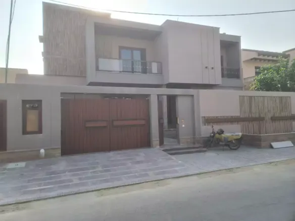 Luxurious Brand New House For Sale In Dha Phase 6 Karachi, Modern Beige Facade With Double Wooden Garage Doors And Balcony