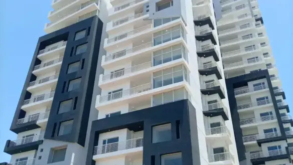 Modern High-Rise Facade Of Dynasty Apartments Clifton With Black And White Panels, Balconies, Large Windows, And Pool Deck