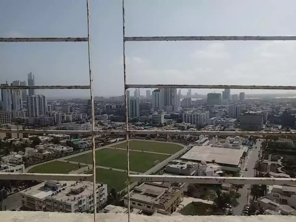 Luxurious 3-Bedroom Apartment for Sale in Green One Clifton Block 8 Karachi (2) Panoramic city view from Greens One Clifton apartment balcony with high-rises, sports field, and urban skyline