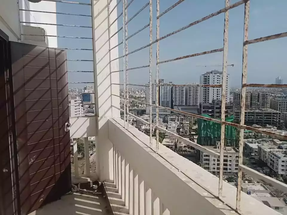 Luxurious 3-Bedroom Apartment for Sale in Green One Clifton Block 8 Karachi (3) Balcony railing and door framing panoramic city skyline view from Greens One Clifton apartment with high-rises