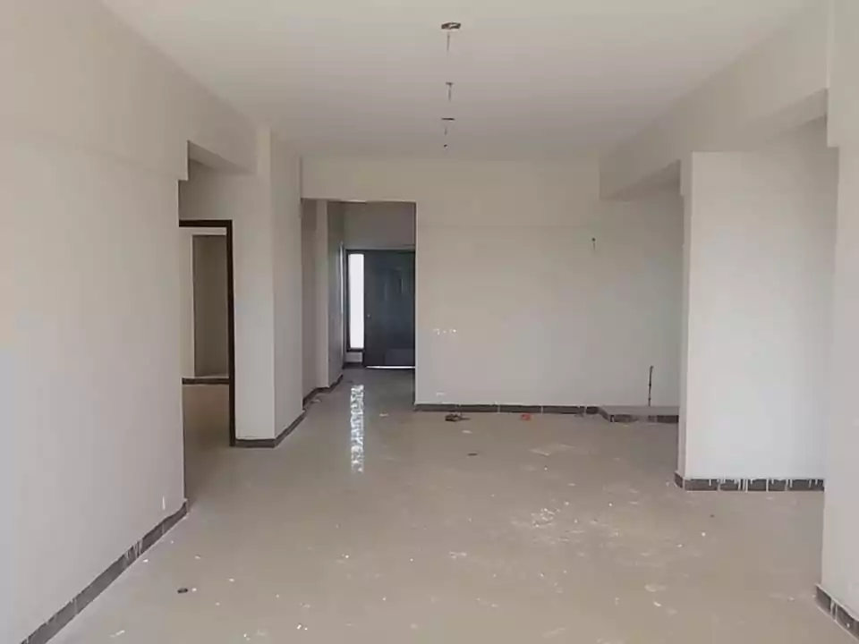 Luxurious 3-Bedroom Apartment for Sale in Green One Clifton Block 8 Karachi (4) Spacious open-plan living area in Greens One Clifton 3-bedroom apartment with white walls, tiled flooring, archways to rooms