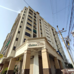 Saima Twin Towers Exterior In Kda Scheme 1, Multi-Story Beige Building With Balconies, Pillars At Entrance, And Signage