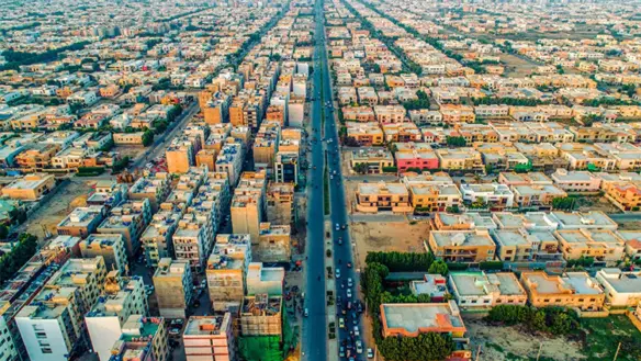 Aerial View Of Dense Residential Buildings And Houses Along A Wide Straight Boulevard In Ameer Khusro, Dha Phase 6 Karachi