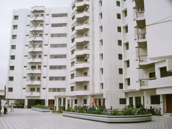 Mehran Twin Towers exterior in Civil Lines: white multi-story building with balconies, courtyard, planters, and residents