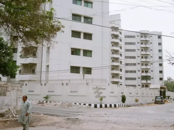 Mehran Twin Towers in Civil Lines, white multi-story building with balconies, large windows, boundary wall, entrance gate and