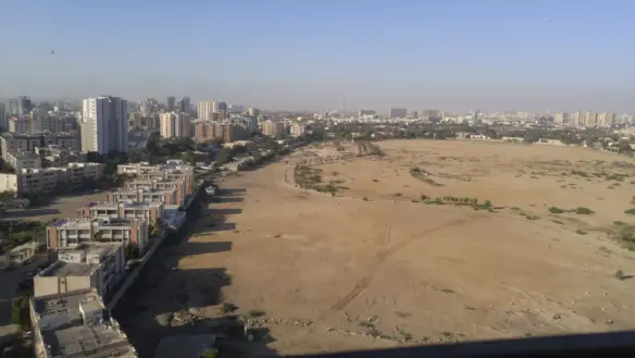 Panoramic view from 10th floor flat in Machiyara Tower Clifton, showing city skyline, residential buildings and open sandy la