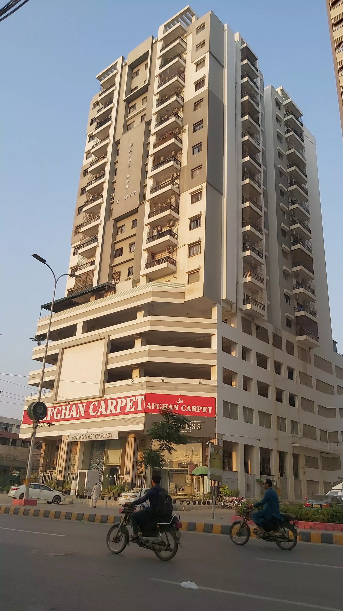 Luxurious Flat for Sale in Machiyara Tower Block 8 Clifton Karachi (6) Machiyara Tower in Clifton, tall high-rise building with balconies, modern facade, ground level entrance and street surroundi