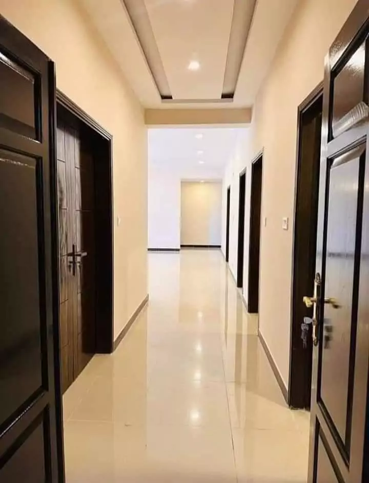 Luxurious 3 Bedroom Flat for Rent in Askari 5, Sector J Malir Cantonment Karachi (6) Spacious hallway with dark wooden doors, beige walls, recessed ceiling lights, polished tile floor in 3-bedroom flat for rent
