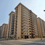 Multi-Story Beige Apartment Buildings In Askari 5 Karachi With Balconies, Glass Railings, Main Entrance, And Street View