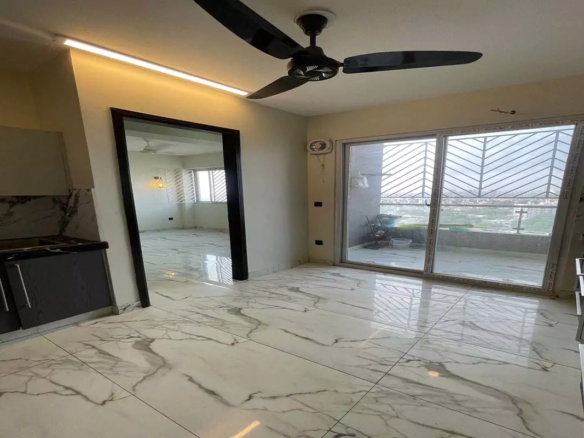 Modern kitchen with grey cabinets, marble tiled floors, ceiling fan, LED lights, and balcony doors in Clifton Marina Block 7 