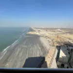 Sea-Facing View From Pearl Tower 3 Flat Balcony Showing Ocean Waves, Sandy Beach, Distant Construction, And High-Rises