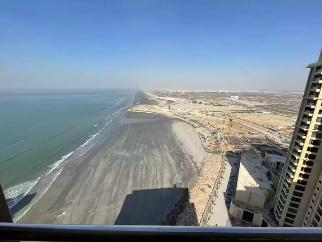 Expansive sea-facing view from luxury flat in Pearl Tower 3 Emaar, showing ocean, beachfront, construction, and high-rises