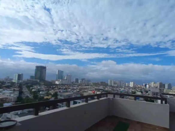 Panoramic Balcony View Of City Skyline With High-Rise Buildings, Urban Neighborhoods, And Partly Cloudy Tropical Sky