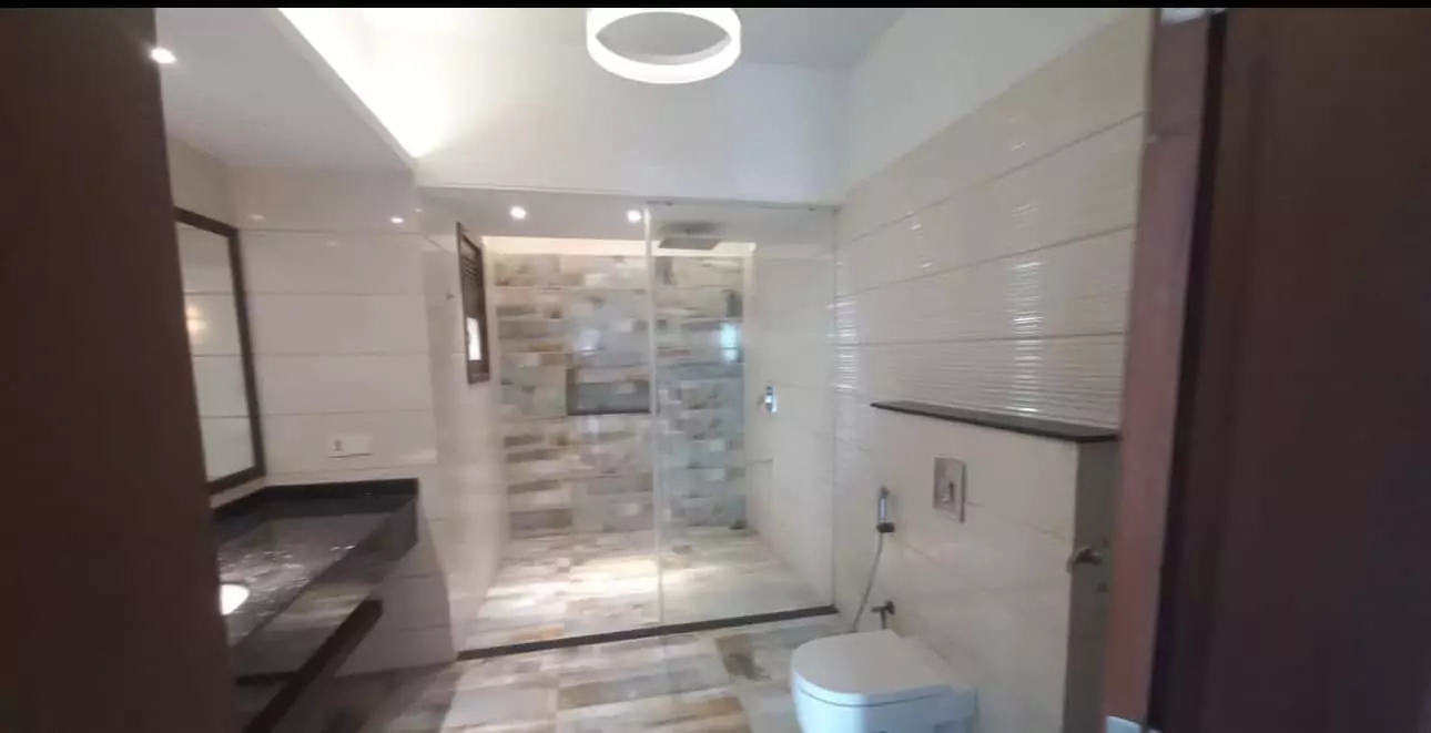 Luxurious 5-Bed Penthouse for Rent in Mall Square Zamzam – DHA Phase 5 Karachi (11) Elegant bathroom in luxurious 5-bed penthouse for rent in Mall Square DHA featuring glass shower, tiled vanity, and modern fi