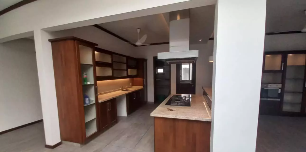 Luxurious 5-Bed Penthouse for Rent in Mall Square Zamzam – DHA Phase 5 Karachi (6) Modern kitchen with wooden cabinets, granite counters, gas stove, chimney hood in 5-bed penthouse for rent in Mall Square DHA