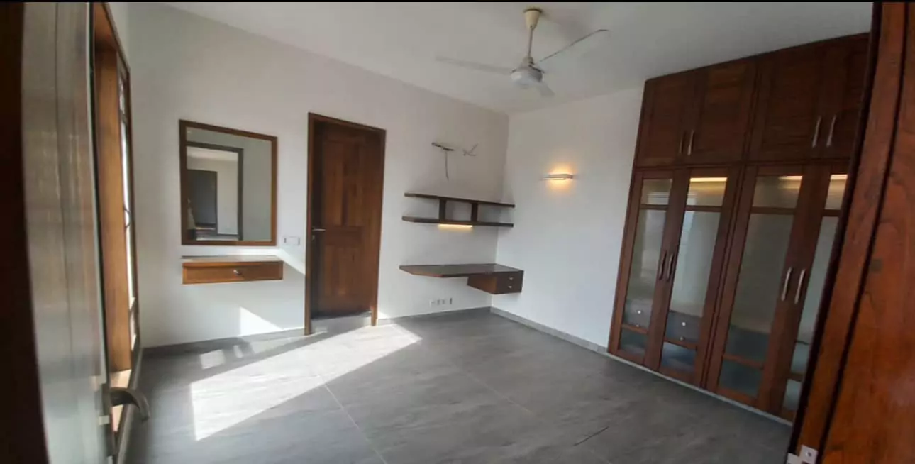 Luxurious 5-Bed Penthouse for Rent in Mall Square Zamzam – DHA Phase 5 Karachi (7) Spacious bedroom in 5-bed penthouse for rent in Mall Square DHA with wooden wardrobes, glass doors, mirror, shelves, ceiling