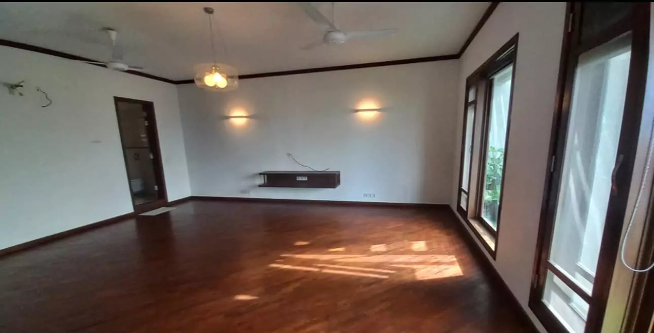 Luxurious 5-Bed Penthouse for Rent in Mall Square Zamzam – DHA Phase 5 Karachi (9) Spacious living room in 5-bed penthouse for rent in Mall Square DHA with polished wooden floors, large windows, ceiling fans,