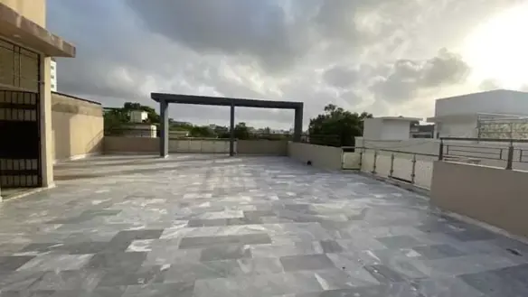 Spacious Rooftop Terrace Of Luxury Townhouse For Sale In Pechs Karachi With Gray Tiled Flooring, Central Pergola, Railings An